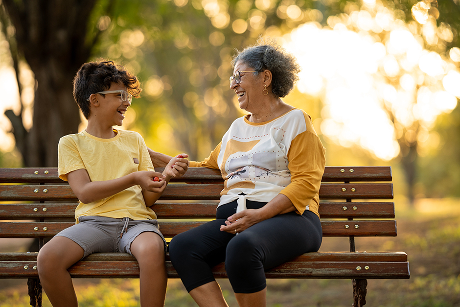 Young kid with his grandmother sitting on a bench